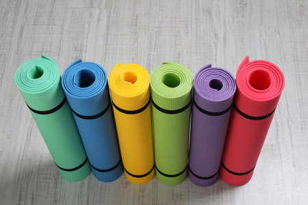 Bright rolled camping mats on white wooden backgroundの写真素材