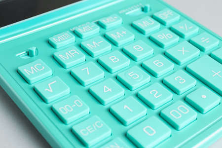 Close up view of turquoise calculator on light background