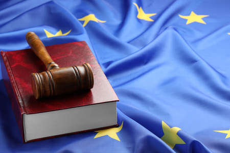 Wooden judge's gavel and book on flag of European Union, space for text