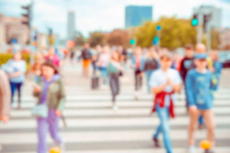 People crossing street in city, blurred view