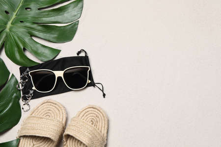 Flat lay composition with stylish sunglasses and black cloth bag on sand. Space for textの写真素材
