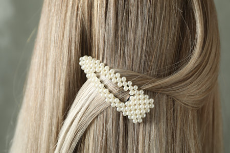 Young woman with beautiful hair clip on gray background, closeupの写真素材