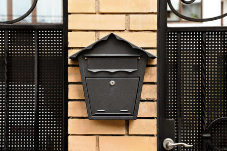 Vintage letter box on beige brick wall near door outdoors