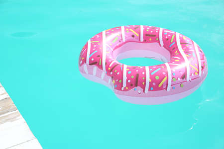 Inflatable ring in swimming pool on sunny dayの写真素材