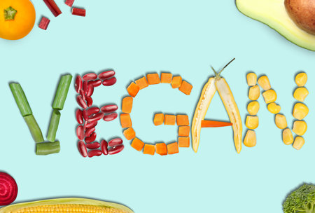 Word VEGAN made of different fresh tasty vegetables on light blue background, flat layの写真素材