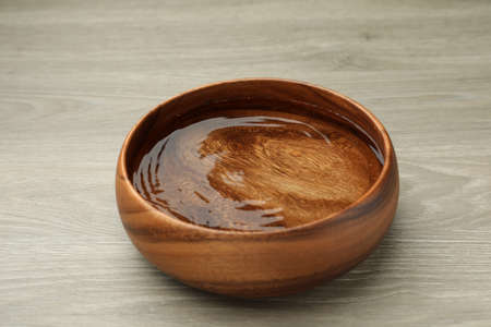 Bowl with water on wooden table, closeupの写真素材