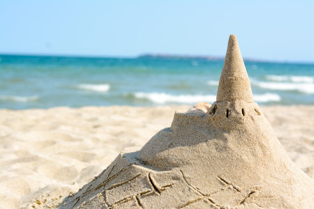 Beach with sand castle near the sea on a sunny day. Space for textの写真素材