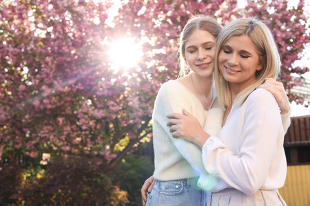 Happy mother with her daughter spending time together in park on sunny dayの写真素材