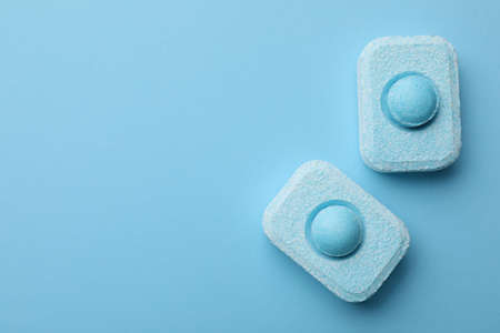 Water softener tablets on light blue background, flat lay. Space for textの写真素材
