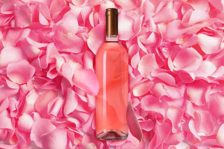 Bottle of delicious rose wine and pink petals, top viewの写真素材