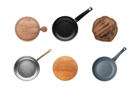 Set with pans and wooden cutting boards on white background, top viewの写真素材