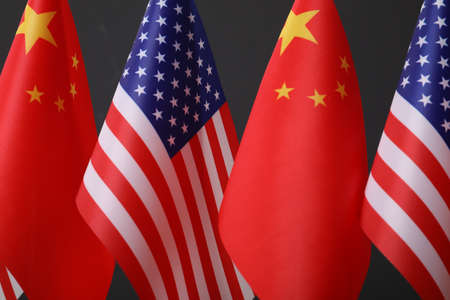 USA and China flags on dark background, closeup. international relations
