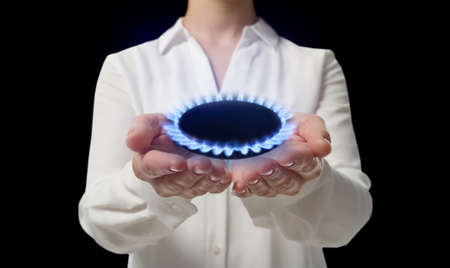Closeup view of woman holding gas burner with blue flame on black background