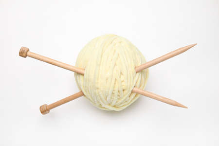 Soft yarn with knitting needles on white background