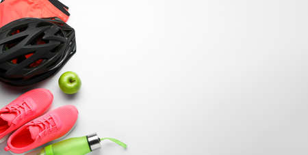 Flat lay composition with different cycling accessories and clothes on white background, space for...