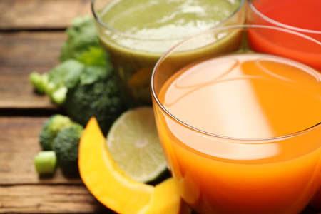 Delicious vegetable juices and fresh ingredients on wooden table, closeupの写真素材