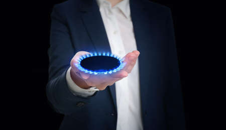Closeup view of woman holding gas burner with blue flame on black background