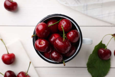 Fresh ripe cherries with water drops on white wooden table, flat layの写真素材