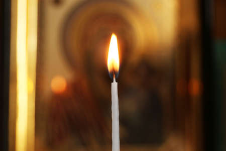 One burning candle in church, closeup view