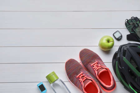 Flat lay composition with different cycling accessories on white wooden background, space for textの写真素材