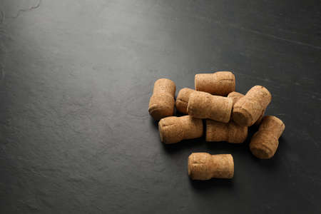 Pile of sparkling wine corks on black table. Space for textの写真素材