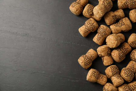 Sparkling wine corks with grape images on black table, flat lay. Space for textの写真素材