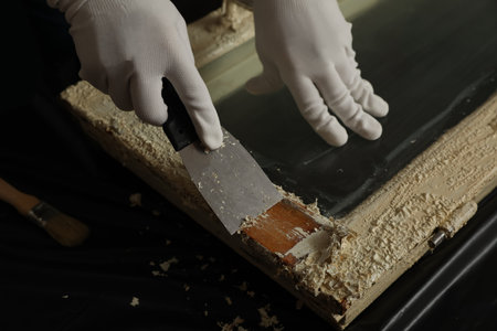 Man repairing old damaged window at table indoors, closeupの写真素材