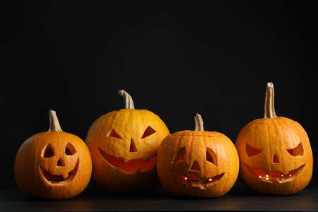 Pumpkins with scary faces on black background. halloween traditional decorの写真素材