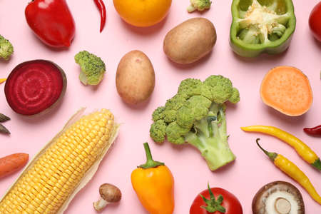 Flat lay composition with fresh vegetables on pink background