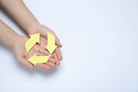Woman holding Recycling symbol made of paper on white background, top view. Space for text