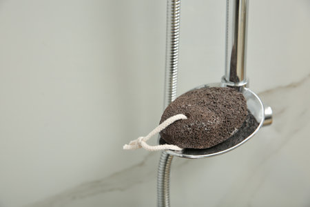 Pumice stone on metal shelf in bathroom, space for textの写真素材