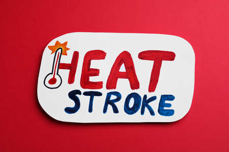 Card with words Heat Stroke and thermometer on red background, top viewの写真素材