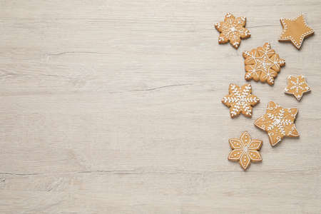 Tasty Christmas cookies on beige wooden table, flat lay. Space for text
