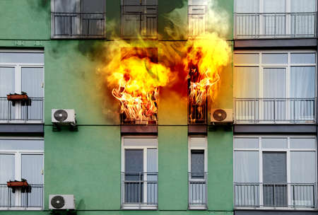 Modern building engulfed in flames. fire safety violationsの写真素材