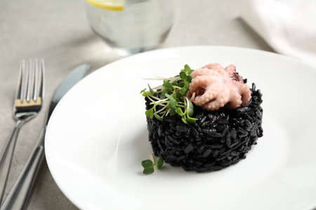 Delicious black risotto with baby octopus on light table, closeupの写真素材