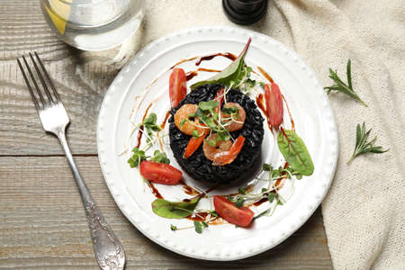 Delicious black risotto with seafood served on wooden tableの写真素材