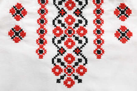 Beautiful red Ukrainian national embroidery on white fabric, top view