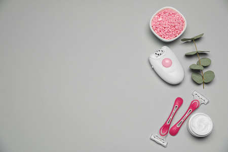 Flat lay composition with epilator and other hair removal products on light gray background. Space for textの写真素材