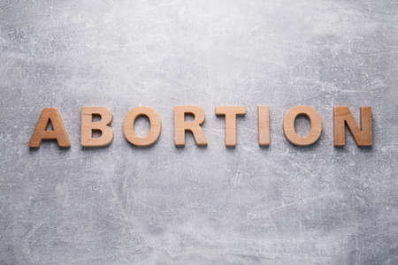 Word Abortion made of wooden letters on gray background, flat layの写真素材