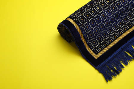 Muslim prayer rug on yellow background, space for textの写真素材