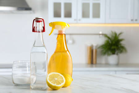 Vinegar, baking soda and lemon on white marble table in kitchen, space for text. Eco-friendly natural detergentsの写真素材