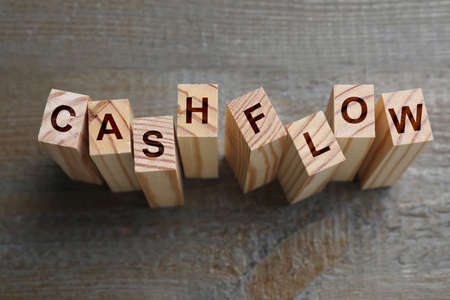Blocks with phrase Cash FLow on black wooden background, above viewの写真素材