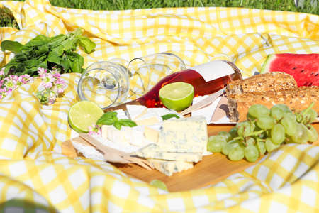 Picnic blanket with delicious food and wine outdoors on sunny dayの写真素材