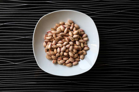 Many tasty pistachios on black table, top viewの写真素材