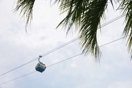 Cableway with cabin against cloudy sky, low angle viewの写真素材