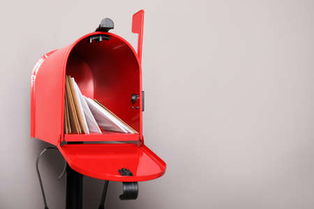 Open red letter box with envelopes against gray background. Space for textの写真素材