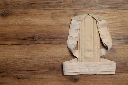 Beige posture corrector on wooden table, top view. Space for textの写真素材