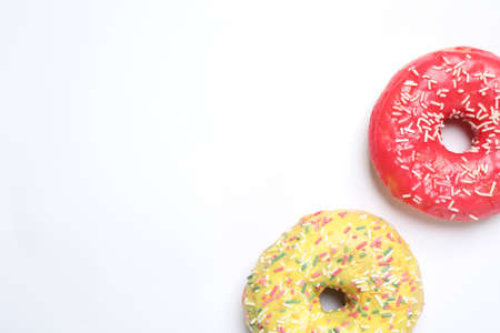 Delicious glazed donuts on white background, flat lay. Space for textの写真素材