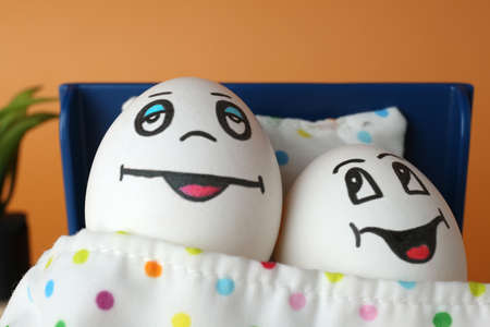 Eggs with drawn happy faces in small bed, closeupの写真素材