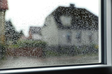 Blurred view of city street from window on rainy dayの写真素材